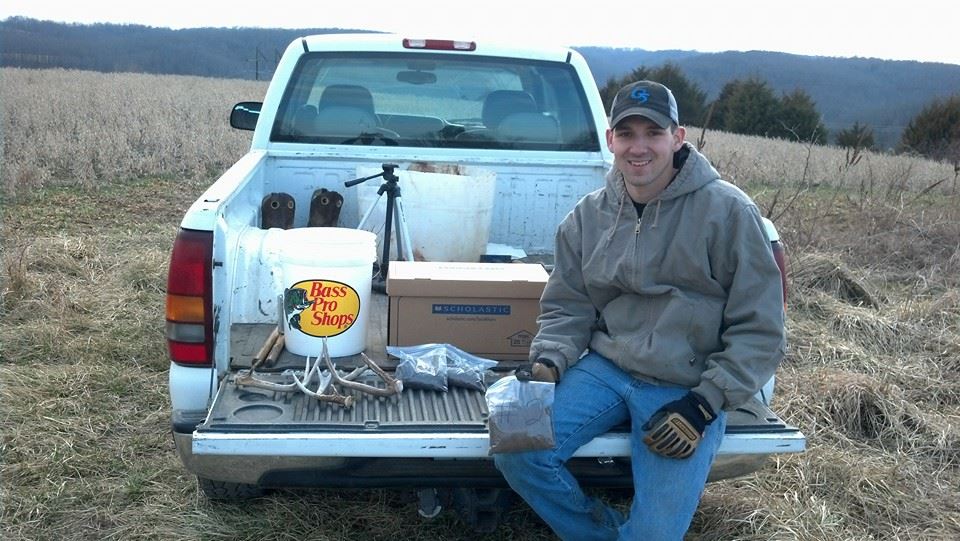 Brain sitting on truck tailgate with a bagged soil sample and shed antlers