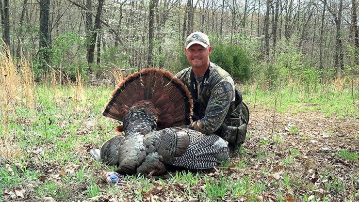 Adam Brooke with a recently killed wild turkey with the fan spread