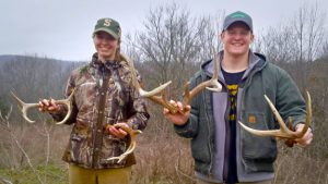 Interns Jessica and Tyler holding shed antlers.
