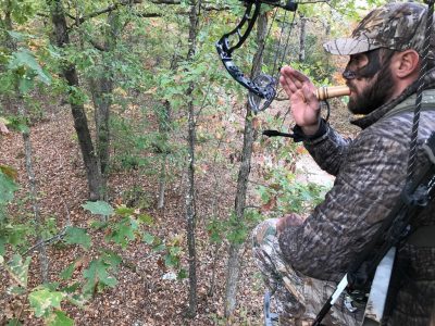 A hunter in a tree using a Messenger grunt call.