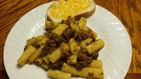 Cubed venison and a pile of onions cooked down and served over pasta.