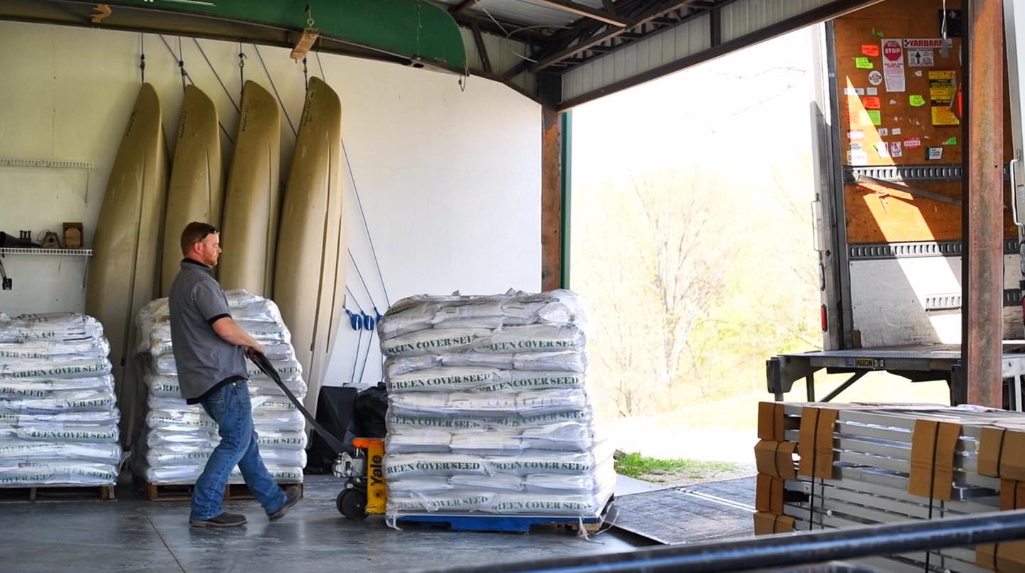 Pallet of green cover seed being unloaded from truck